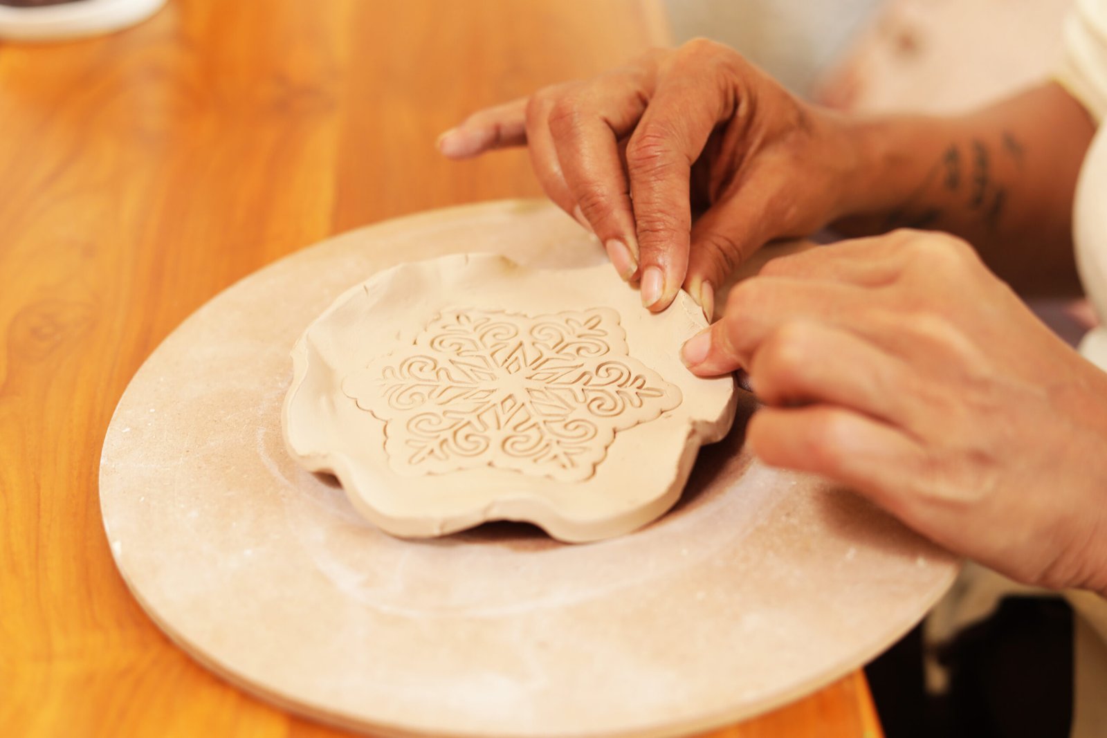 A woman shaping a clay vessel by hand
